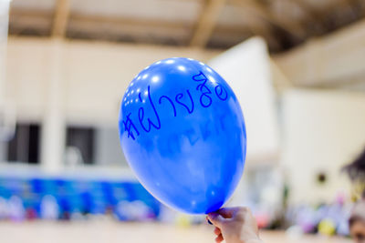 Close-up of hand holding balloons