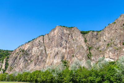 Low angle view of rock formation against clear blue sky