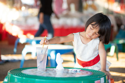 Full length of a girl having food on table