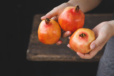 Midsection of woman holding pomegranates