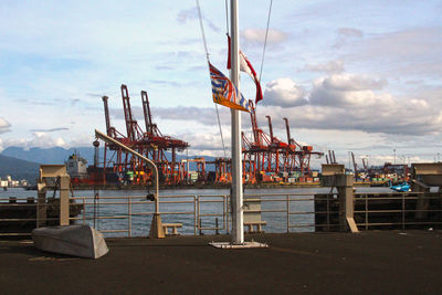 Cranes in sea against sky