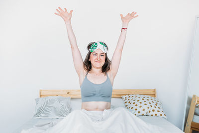 Portrait of smiling young woman sitting on bed