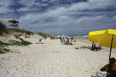 People on beach against sky