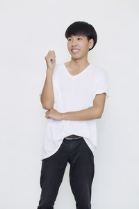 Portrait of smiling boy standing against white background