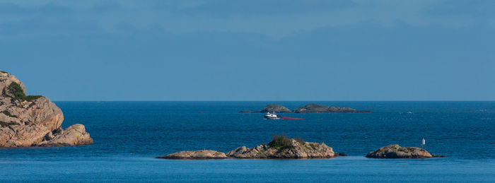 Small trawler heading for port with a red trawl
