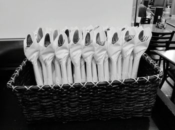 Spoons and forks covered with napkins in wicker basket