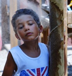 Cute boy standing by spraying water