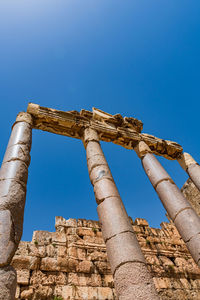 Low angle view of old ruins against clear blue sky