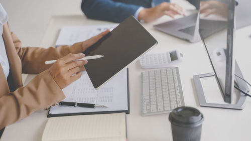Midsection of man using laptop on table