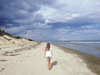 Scenic view of beach against cloudy sky