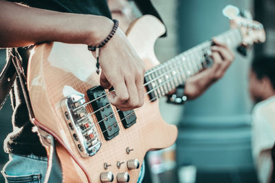 Midsection of man playing guitar