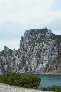Rock formations by sea against sky