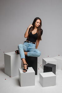 Portrait of woman sitting against wall