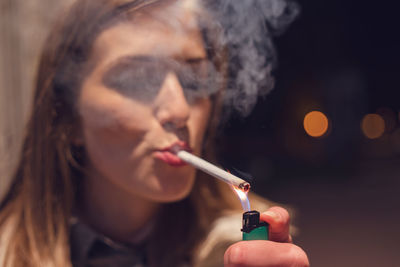 Close-up of woman lighting cigarette