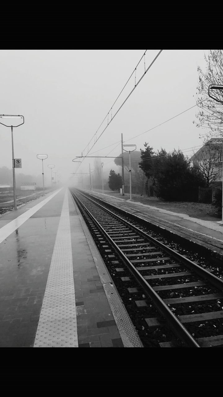 RAILROAD TRACKS AGAINST SKY AT STATION