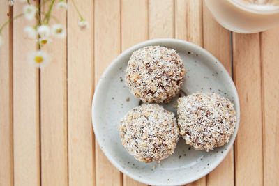 Vegan handmade delight - gluten and sugar free natural balls sweets and coffee on the wooden table 