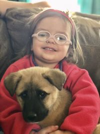 Portrait of a smiling young woman with dog at home