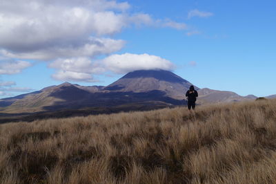 Man standing on field against sky