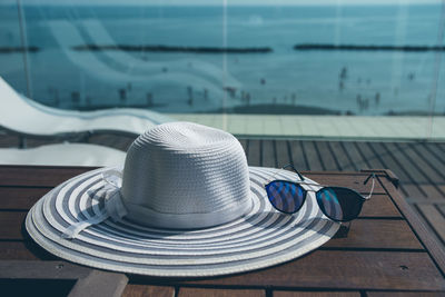 Hat by sunglasses on table