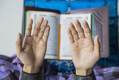 Cropped hands praying at home