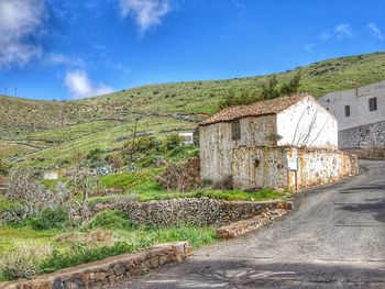 Road amidst buildings against sky