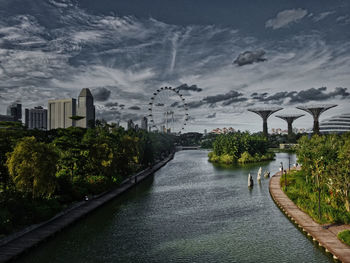 Bridge over river in city against sky
