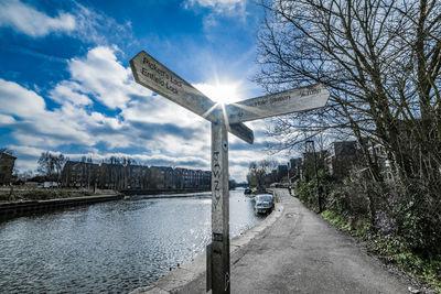 Road by river in city against sky