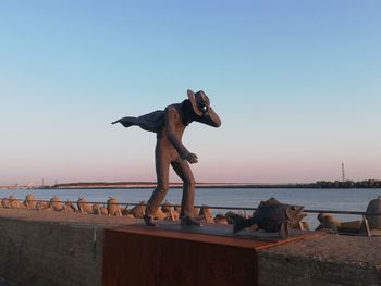 Sculpture on beach against clear sky