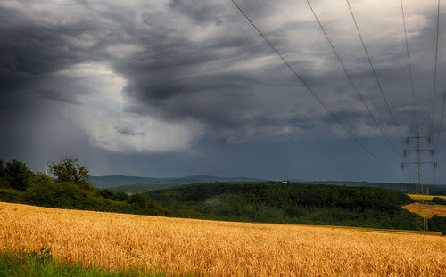 Scenic view of field against storm clouds