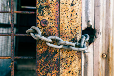 Close-up of rusty chain on metal gate