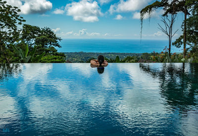 Rear view of woman in infinity pool