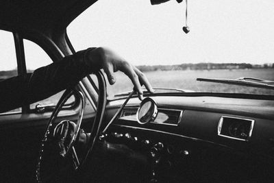 Cropped hand of woman driving car