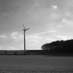 Windmill on field against sky