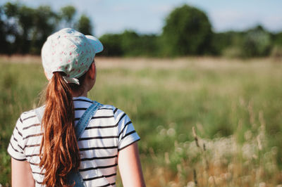 Rear view of girl standing on field