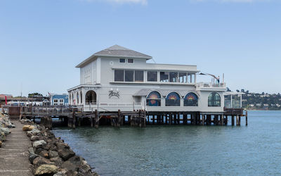 Building by sea against clear sky