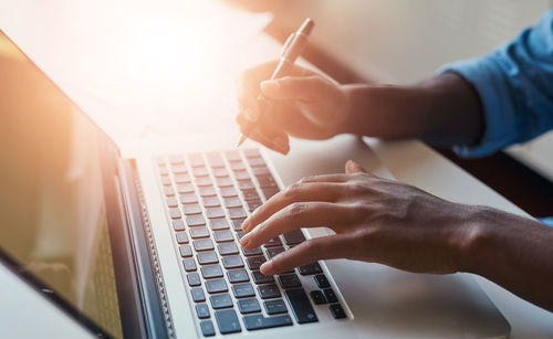 Cropped hands using laptop