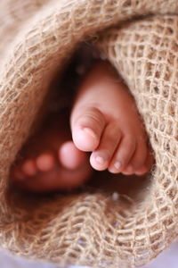 Low section of baby wrapped in burlap