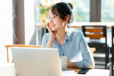 Young woman using laptop at home