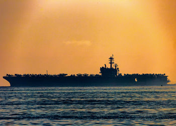 Silhouette ship sailing on sea against sky during sunset