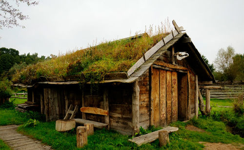 Old abandoned building on field against sky