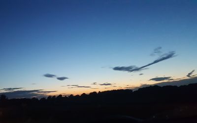 Scenic view of silhouette landscape against blue sky