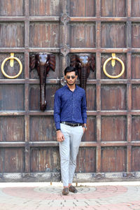 Portrait of smiling man standing against wall