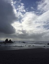 View of beach against cloudy sky