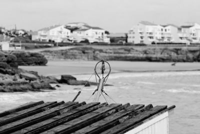 Pulley on hut by sea against sky