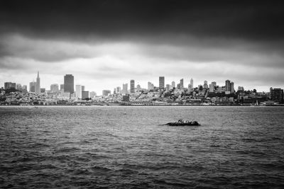 Scenic view of sea by buildings against sky