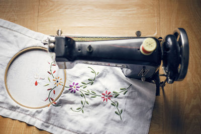 Overhead view of fabric and embroidery machine on wooden table