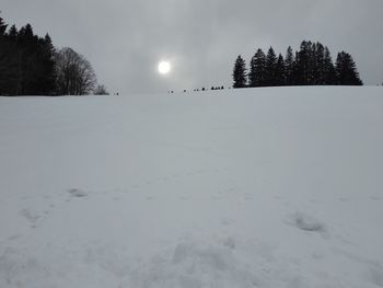 Snow covered field against sky