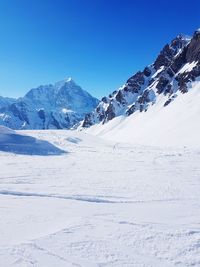 Scenic view of snowcapped mountains against clear blue sky