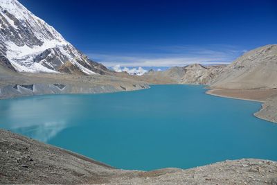 Panoramic view of lake and snowcapped mountains against blue sky