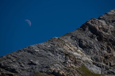 Low angle view of rock formation against clear blue sky